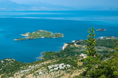 Bakış açısı Donji Murici. Arnavutluk sınırı yakınlarındaki Skadar Gölü 'nün küçük yeşil adaları ve mavi sularından oluşan güzel bir yaz manzarası. Açık mavi gökyüzü. Karadağ. Seyahat kavramı.
