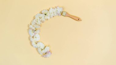 Fırça, kasımpatı ile beyaz çiçek başlarından oluşan yarı daire bir çerçeve çizer. Uzayı kopyala Metin ya da tasarım için şablon. Tatil tebrik kartı. Sarı arkaplan.