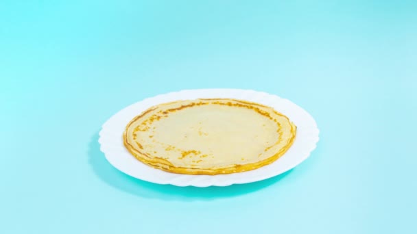 4Kパンケーキは白いプレートの上に次々と現れ スタックを形成します パンケーキが消えます おいしい料理のコンセプト 動くなよ ターコイズの背景 — ストック動画