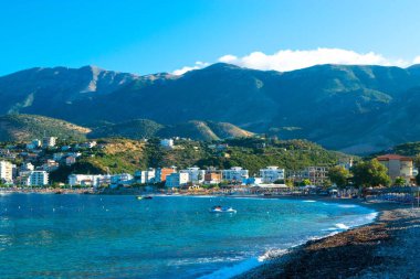 Himare 'nin dağların eteğindeki güzel çakıl taşı plajı. Adriyatik Denizi. Arnavutluk. Yaz sabahı manzarası. Yaz tatili ve rahatlama kavramı.