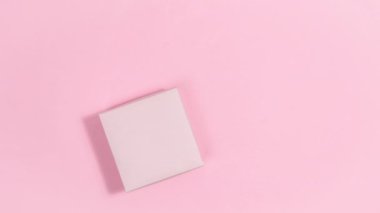 4k Pink gift box is tied with red ribbon and decorated with heart-shaped white chocolate candy on stick. Greeting card for valentine's day. Pink background. Copy space. Flat lay. Stop motion animation