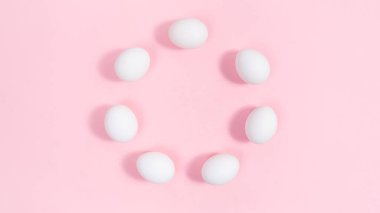 White eggs arranged in a circle. Pink background. Minimal concep of nutrition, protein or Easter holiday. Greeting card. Template for design or text.