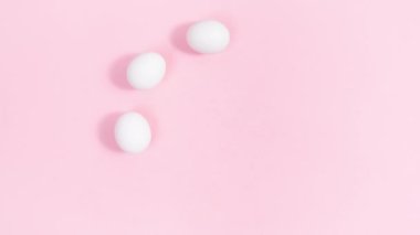 4k White eggs arranged in a circle are decorated with buds of natural flowers and green leaves. Pink background. Easter holiday. Greeting card. Template for design or text. Stop motion animation.
