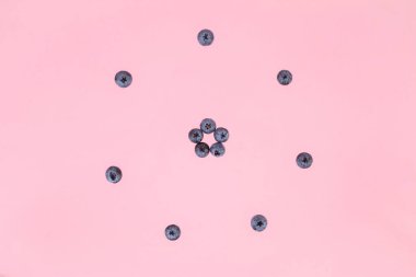 Berries of blueberries arranged in a circle. Pink background. Concept of berries season and proper nutrition. Flat lay. Copy space.