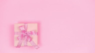 4k Happy mother's day, women's day, valentine's day or birthday holiday. Pastel pink background. Gift box beautifully decoreted natural flowers. Floral flat cards. Copy space. Stop motion animation.