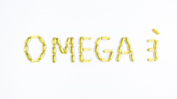 単語オメガ3は魚油と黄色の透明なカプセルから並んでいます タブレットは 気泡を放出する小さな魚のようなテキストの周りに浮かんでいます 白地だ 健康の維持 — ストック動画