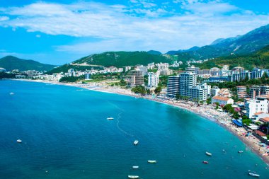 Dağın eteklerinde yer alan Becici ve Rafailovici tatil köylerinin panoraması. Karadağ. Adriyatik Denizi. Yaz güneşli bir gün. Deniz kenarı tatil kavramı.