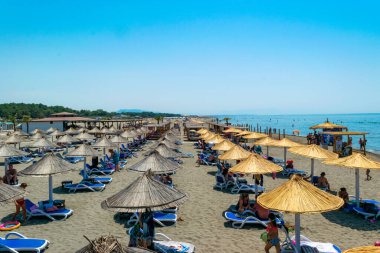 Ulcinj, Karadağ - 09 Temmuz 2021: Kum Long Beach 'te (Velika Plaza) şemsiyeli ve güneşli tatilciler. Güneşli mavi deniz manzarası. Adriyatik Denizi.