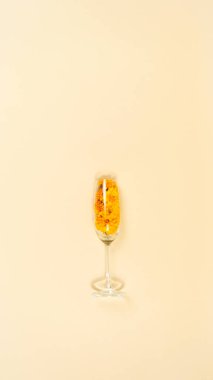 Turuncu kadife çiçekli ve yapraklı cam. Açık sarı arkaplan. Tatil, doğa ya da kadınlar günü konsepti. Boşluğu kopyala.