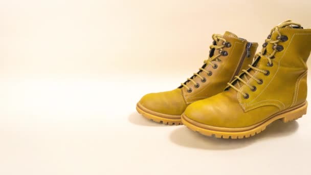 Κίτρινες Φθινοπωρινές Μπότες Πατάνε Μπεζ Φόντο Φθινοπωρινή Ιδέα Φθινοπωρινή Ψύξη — Αρχείο Βίντεο