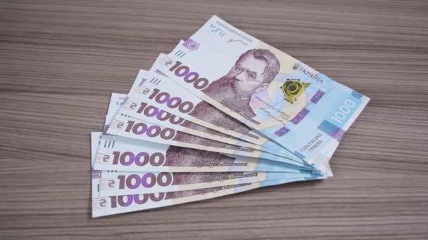 Dłoń Kobiet Zabiera Tysiąc Hrywien Ukraińskich Banknotów Leżących Stole Pojęcie — Wideo stockowe