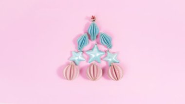 4k Noel ağacı pembe toplar ve mavi yıldızlardan oluşur. Dekoratif Noel oyuncakları. Güzel bir tatil manzarası. Düz yatıyordu. Hareket animasyonunu durdur. Tasarım ve metin için tebrik kartı veya şablon.