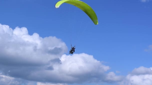 パラグライダー インストラクターのパラグライダーは 飛行中に空に旅客ホバーと並んでいます パラシュートトリック 夏の晴れた日 ハイマウンテンカルパティア風景 — ストック動画