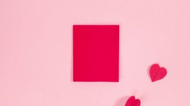 Kırmızı kartın yanında, mesaj için fotokopi alanı var. Kelebek gibi kanatlarını sallıyorlar. Tebrik kartı. Soluk pembe arka plan. Hareketi durdur.