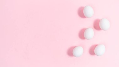 Bir grup beyaz yumurta. Pembe arka plan. Beslenme, protein veya Paskalya tatili için minimum konsept. Tasarım veya metin şablonu. 