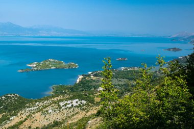 Bakış açısı Donji Murii. Arnavutluk sınırı yakınlarındaki Skadar Gölü 'nün küçük yeşil adaları ve mavi sularından oluşan güzel bir yaz manzarası. Açık mavi gökyüzü. Karadağ. Seyahat kavramı.