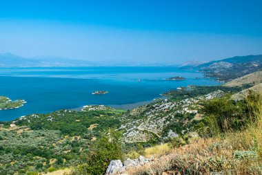Bakış açısı Donji Murii. Arnavutluk sınırı yakınlarındaki Skadar Gölü 'nün küçük yeşil adaları ve mavi sularından oluşan güzel bir yaz manzarası. Açık mavi gökyüzü. Karadağ. Seyahat kavramı.