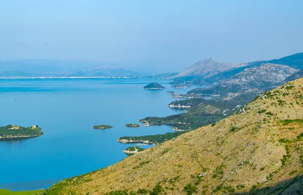 Shtegvashe Bakış Açısı. Arnavutluk sınırı yakınlarındaki Skadar Gölü 'nün küçük yeşil adaları ve mavi sularından oluşan güzel bir yaz manzarası. Açık mavi gökyüzü. Karadağ. Seyahat kavramı.