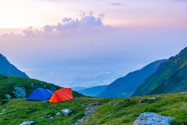 Tourist tents near the pass of Transfagarasan road, is one of most beautiful roads in world. Carpathians. Romania. Beautiful landscape of high mountains at sunset. clipart