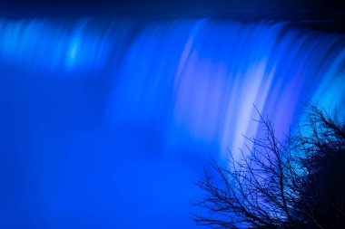 Niagara Şelalesi 'nin bulanık akıntıları, akşamları maviyle aydınlanıyor. Kanada mı? Dünyanın en önemli eğlencelerinden biri. Yakın plan..