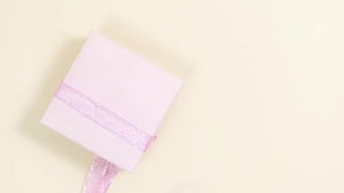 Güzel hediye kutusundan doğal gül çiçekleri ve beyaz kağıtlar çıkar. Metin için şablon. Doğum günü kartı, anneler günü, kadınlar günü ya da başka bir gün için tebrik kartı. Bej arka plan. Boşluğu kopyala.