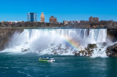 American Falls ve Bridal Veil Falls 'un güzel manzarası Niagara Şelalesi makyajlı şelalelerdir. Gökkuşağı ve turizm ön planda. Kanada tarafından Amerika Birleşik Devletleri tarafına bak. Güneşli bir gün. Mavi gökyüzü.