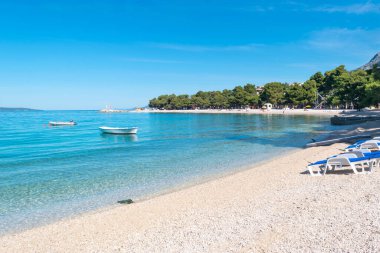 Yaz mevsiminde sakin Adriyatik Denizi. Güneşli bir sabahta temiz küçük çakıl taşı plajı. Promajna, Hırvatistan. Adriyatik Denizi kıyısında muhteşem çam ağaçları yetişir. Tatil konumu.