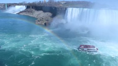 American Falls 'un güzel manzarası, gelinlik şelalesi ve at nalı şelalesi. Niagara Şelalesi. Turistli gemi şelale ve su bulutuna doğru yelken açıyor. Ön planda gökkuşağı. Kanada tarafı.