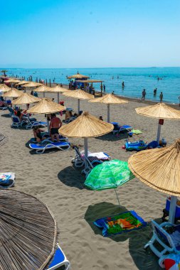 Ulcinj, Karadağ - 09 Temmuz 2021: Kum Long Beach 'te (Velika Plaza) şemsiyeli ve güneşli tatilciler. Güneşli mavi deniz manzarası. Adriyatik Denizi.