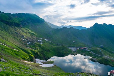 Balea Gölü kıyısındaki Chalets Fagaras Dağları 'ndaki buzul gölüdür. Transfagarasan dağ yolu, dünyanın en güzel yollarından biridir. Güzel dağların manzarası. Karpatlar. Romanya.
