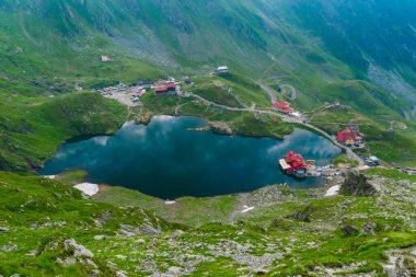Balea Gölü kıyısındaki Chalets Fagaras Dağları 'ndaki buzul gölüdür. Transfagarasan dağ yolu, dünyanın en güzel yollarından biridir. Güzel dağların manzarası. Karpatlar. Romanya.