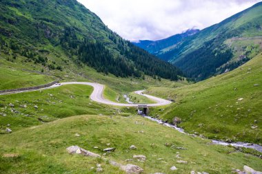 Serpentine Transfagarasan yolunda keskin virajlardaki arabalar dünyanın en güzel yollarından biridir. Yeşil dağ yamaçları. Karpatlar. Romanya.