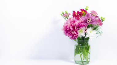 Cam kavanozda, kağıt kalpli, güzel, taze çiçek buketi belirir. Beyaz arka plan. Doğum günü kartı, anneler günü, kadınlar günü ya da başka bir gün için tebrik kartı. Metin şablonu. Boşluğu kopyala.