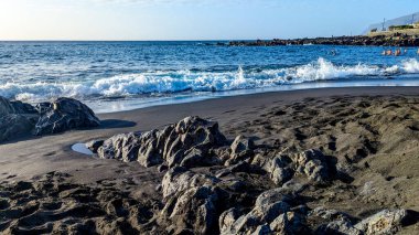 Playa de la Arena, Kanarya Adaları, Tenerife, İspanya. Siyah volkanik kumu olan plaj. Atlantik kıyısı. Güzel manzara. Benzersiz tropikal iklim tüm yıl boyunca yüzmeye izin verir..