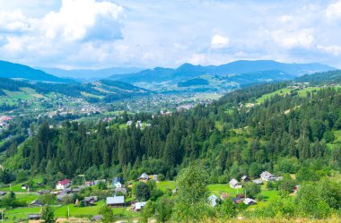 Karpat Dağları ve Verkhovyna köyünün güzel yaz manzarası. Ukrayna. Mavi bulutlu gökyüzü ve yeşil köknar ağaçları.