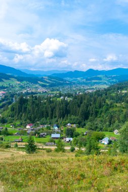 Karpat Dağları ve Verkhovyna köyünün güzel yaz manzarası. Ukrayna. Mavi bulutlu gökyüzü ve yeşil köknar ağaçları.