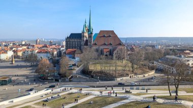 Erfurt, Almanya - 8 Mart 2025: Mavi gökyüzüne karşı Erfurt Ortaçağ Katedrali ve St. Severus Kilisesi. Baharın başında güneşli şehir manzarası. Petersberg Kalesi 'nin duvarından görüntü.