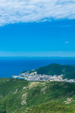Budva şehrinin tepesinden bak. Karadağ 'daki Adriyatik Denizi' nde Budva Riviera. Mavi gökyüzüne karşı yeşil dağların güzel manzarası.