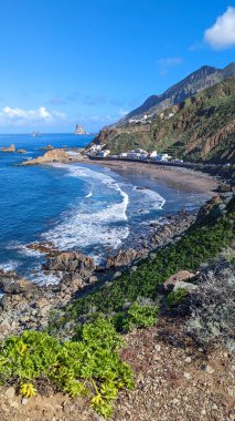 Okyanus sörfünün güzel manzarası. Dalgalar Benijo sahilinde eşsiz siyah-bronz volkanik kumla yuvarlanır. Bulutlu mavi güneşli gökyüzü. Kanarya Adaları, Tenerife. İspanya