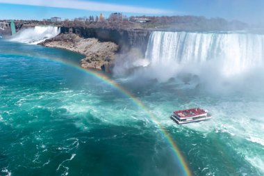 American Falls 'un güzel manzarası, gelinlik şelalesi ve at nalı şelalesi. Niagara Şelalesi. Turistli gemi şelale ve su bulutuna doğru yelken açıyor. Ön planda gökkuşağı. Kanada tarafı.