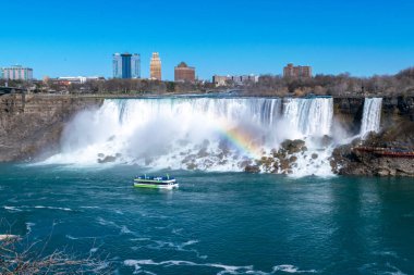 American Falls ve Bridal Veil Falls 'un güzel manzarası Niagara Şelalesi makyajlı şelalelerdir. Gökkuşağı ve turizm ön planda. Kanada tarafından Amerika Birleşik Devletleri tarafına bak. Güneşli bir gün. Mavi gökyüzü.