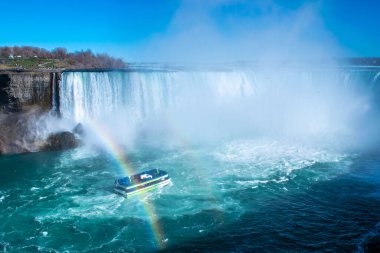 At nalı şelalesinin güzel manzarası, Niagara Şelalesinin en büyük üç şelalesi. Turistli gemi şelale ve yükselen su bulutlarına doğru yelken açıyor. Ön planda gökkuşağı. Kanada tarafından görünüyor..