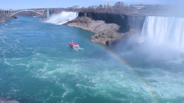 American Falls 'un güzel manzarası, gelinlik şelalesi ve at nalı şelalesi. Niagara Şelalesi. Turistli gemi şelale ve su bulutuna doğru yelken açıyor. Ön planda gökkuşağı. Kanada tarafı.