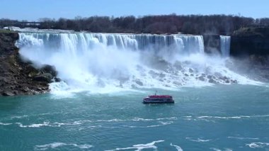 American Falls ve Bridal Veil Falls 'un güzel manzarası Niagara Şelalesi makyajlı şelalelerdir. Gökkuşağı ve turizm ön planda. Kanada tarafından Amerika Birleşik Devletleri tarafına bak. Güneşli bir gün. Mavi gökyüzü.