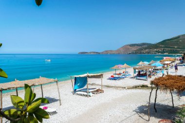 Borsh Beach, Albania - July 14, 202: Vacationers on long beach with clear blue water. Cloudless sky. Ionian Sea. Summer landscape. Concept of summer holidays and relaxation.