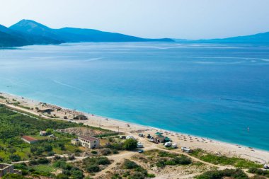 View from the top of the long sandy pebble Borsh beach. Albania. Corfu or Kerkyra island at background. Ionian Sea. Summer sunny landscape.