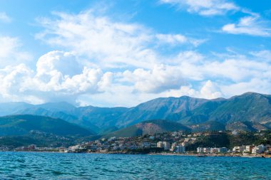Himare sahil kasabasının güzel yaz bulutları İyon ve Adriyatik denizlerinin sınırındaki dağların eteklerinde. Arnavutluk. Yaz tatili ve rahatlama kavramı.