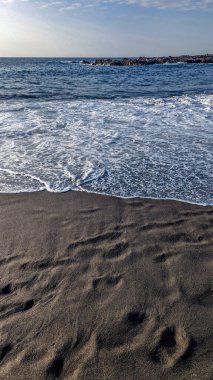 Playa de la Arena, Kanarya Adaları, Tenerife, İspanya. Siyah volkanik kumu olan plaj. Atlantik kıyısı. Güzel manzara. Benzersiz tropikal iklim tüm yıl boyunca yüzmeye izin verir..