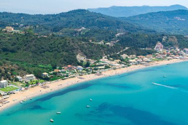 İyon Denizi 'nin gök mavisi sularından ve dağın eteğindeki Agios Georgios köyünün geniş plajlarından harika bir manzara. Plaj tatili için güzel bir yer. Korfu adası. Yunanistan.