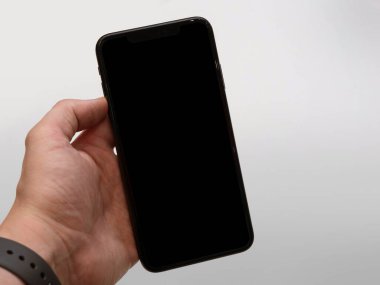 Beyaz arkaplanı olan akıllı telefonu kullanan kişi - boş ekran